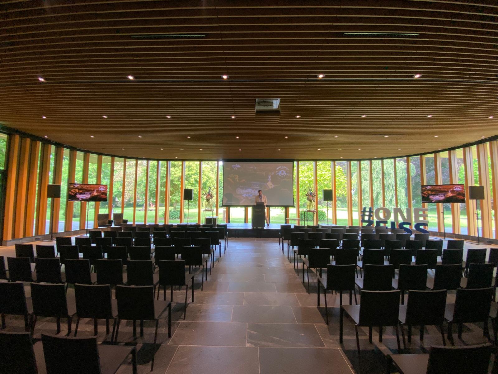 Strakke seminaropstelling met projectiescherm en zaalgeluid